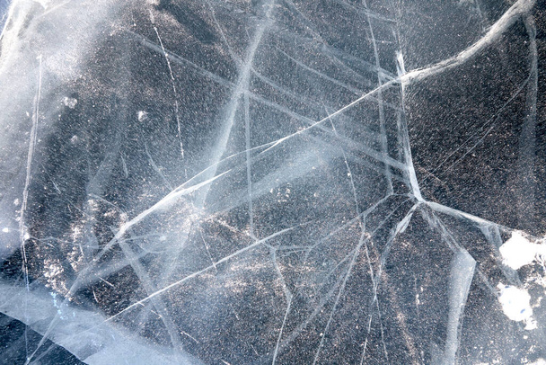 texture of cracks in the clear ice of a frozen lake - 写真・画像