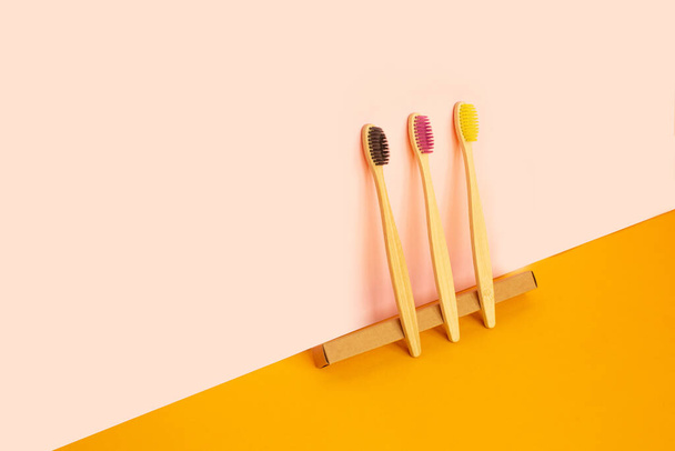 Cepillos de dientes de bambú ecológicos sobre fondo de color de moda. - Foto, Imagen