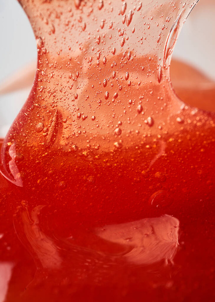 The texture of the red transparent cosmetic gel. Abstract background - Фото, зображення