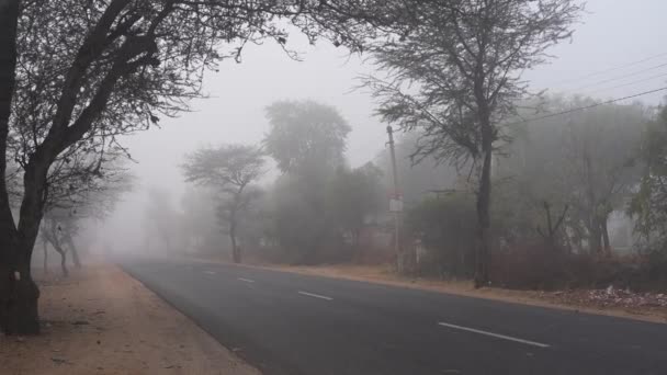 Vista rural de estrada de asfalto com linha branca através do tempo nebuloso nebuloso. Via expressa vazia passando pelo interior da Índia. - Filmagem, Vídeo