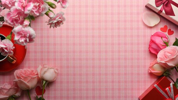 Vista dall'alto del tavolo rosa con spazio copia fiore rosa e scatola regalo decorata sul tavolo - Foto, immagini