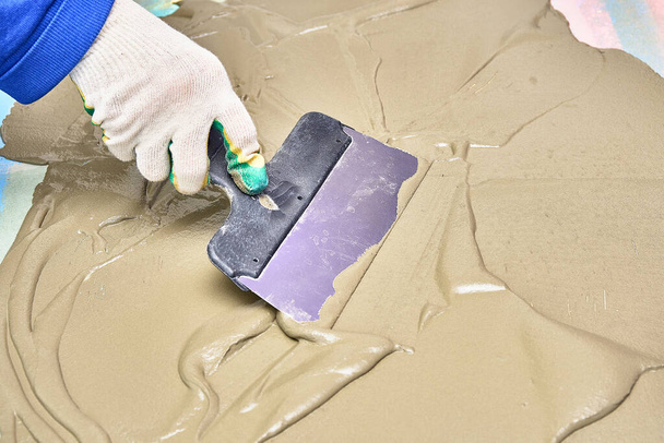 worker in gloves puts plaster with spatula. repair, construction - Foto, Imagem