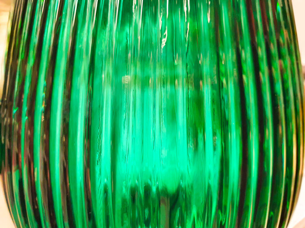 Fondo borroso abstracto disparado a través de un grueso vidrio verde con rayos brillantes. Fondo colorido difuso. Botella de vidrio. - Foto, imagen
