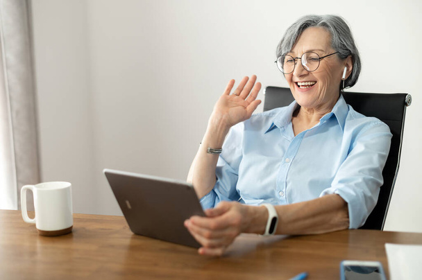Senior female businesswoman showing high five online - Fotó, kép