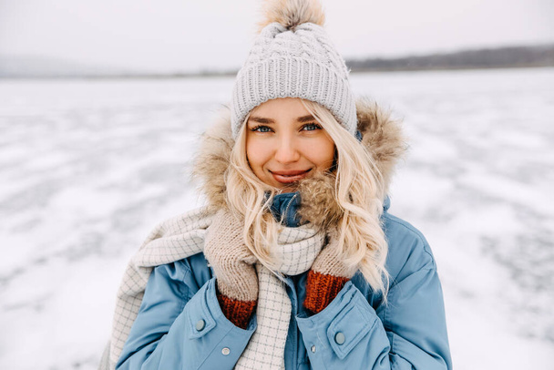 Ritratto ravvicinato di una giovane donna bionda che guarda la macchina fotografica, nella fredda giornata invernale. - Foto, immagini