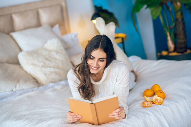 Young beautiful woman reading a book and looking thoughtful - Foto, imagen