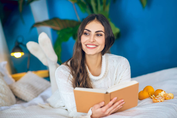 Young beautiful woman reading a book and smiling - Foto, Imagem