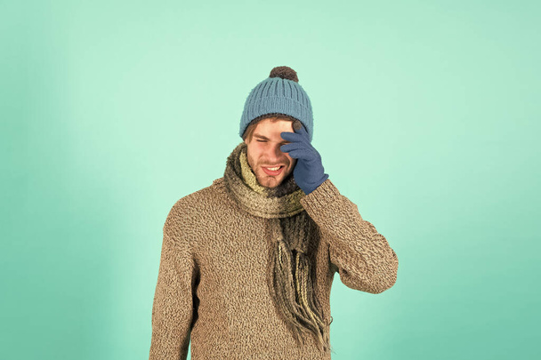 Feeling sorry. Man handsome unshaven guy wear winter accessories on blue background. Winter season sale. Hipster knitted winter hat scarf and gloves. Shopping concept. Emotional expression. Forgot - Photo, Image