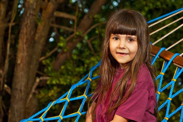 Children sit in a hammock. Girls play in nature in summer. Children's entertainment in the garden. - Foto, immagini