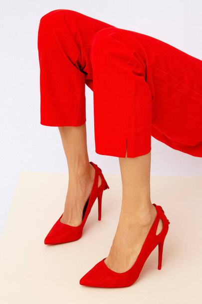 Kırmızı pantolonlu ve ayakkabılı tanınmayan kadın bacakları. Minimalist zarif ayrıntılar biçimi. - Fotoğraf, Görsel