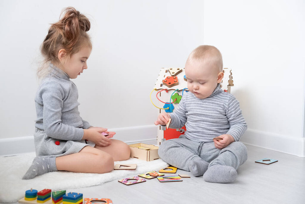 menino brincando com a irmã mais velha com brinquedos de madeira. desenvolvimento precoce das crianças - Foto, Imagem