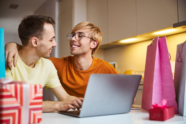 Casal homossexual feliz usando laptop moderno em casa - Foto, Imagem