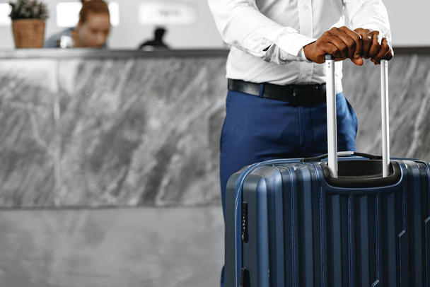 Unrecognizable businessman standing with luggage suitcase in hotel lobby - Foto, Bild