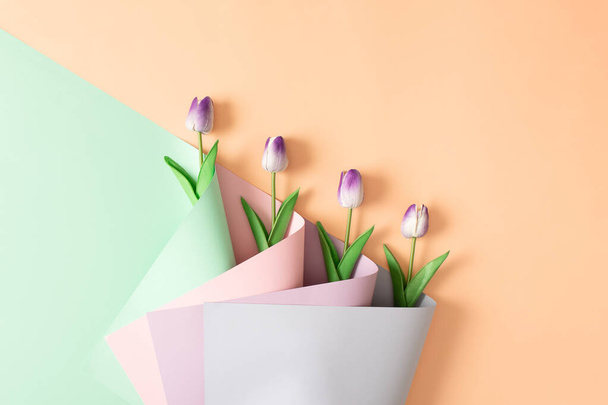 Fialové tulipány v kytici barevných tapet. Úhlopříčka květin. Tvůrčí pozadí koncept lásky. - Fotografie, Obrázek