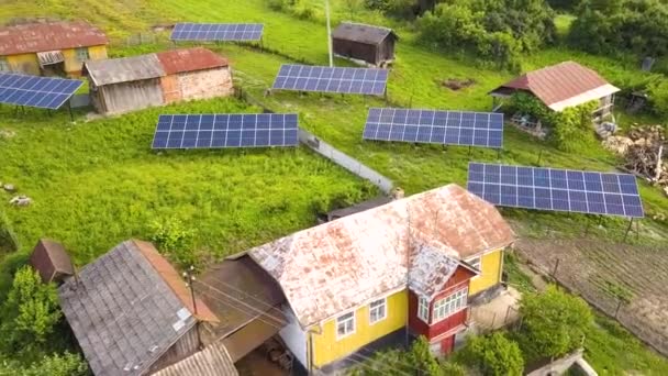 Zicht vanuit de lucht op zonnepanelen in groene landelijke gebieden. - Video
