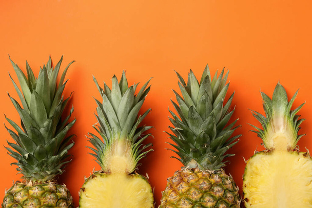 Tasty ripe pineapples on orange background, top view - Photo, Image
