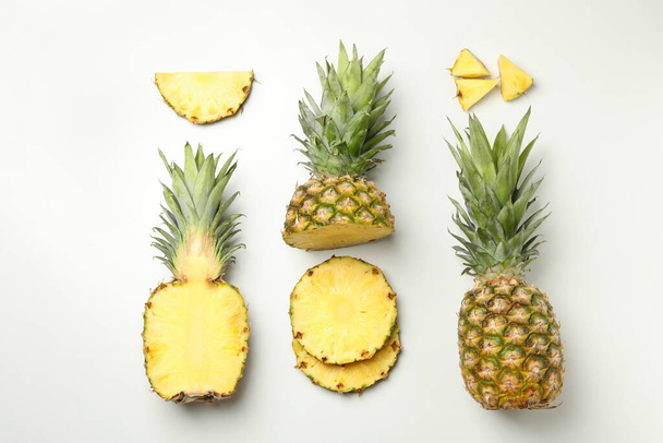 Flat lay with pineapple and slices on white background - Foto, Bild