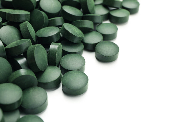 Spirulina in pills isolated on white background - Foto, afbeelding