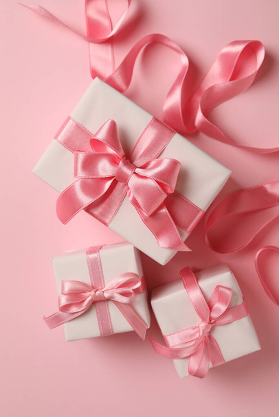 Geschenkschachteln und Schleife auf rosa Hintergrund - Foto, Bild