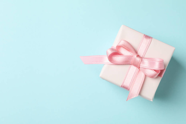 Geschenkdoos met roze lint op blauwe achtergrond - Foto, afbeelding