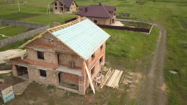 Letecký pohled na cihlový dům s dřevěným střešním rámem ve výstavbě. - Záběry, video