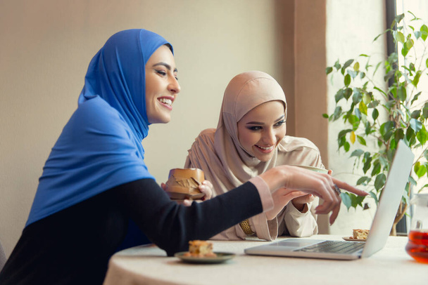 Beautiful arab women meeting at cafe or restaurant, friends or business meeting - Photo, image