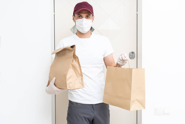 Delivery man holding cardboard boxes in medical rubber gloves and mask. copy space. Fast and free Delivery transport . Online shopping and Express delivery . Quarantine - Valokuva, kuva