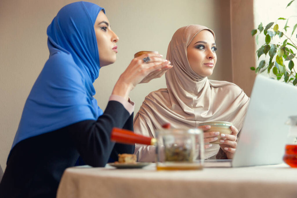 Beautiful arab women meeting at cafe or restaurant, friends or business meeting - Photo, image