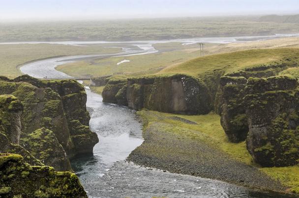 Blick auf die Klippen und einen Fluss von oben, Fjadrargljufur Canyon, Kirkjubaejarklaustur, Island - Foto, Bild