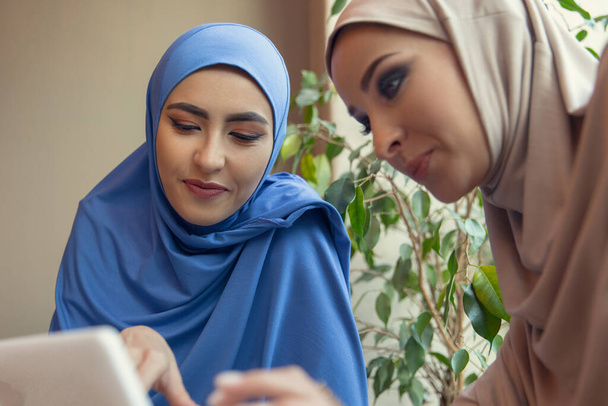 Beautiful arab women meeting at cafe or restaurant, friends or business meeting - Foto, Bild