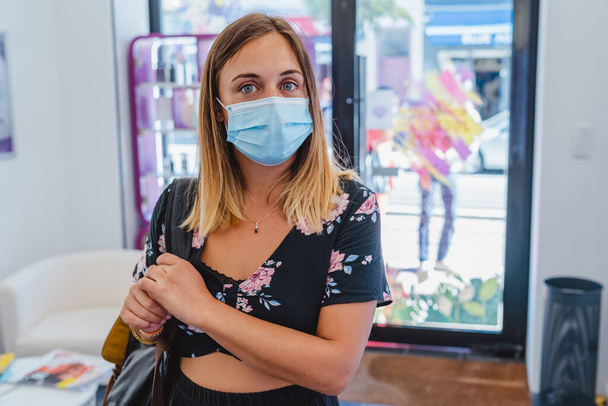 Kaunis naispuolinen asiakas tulee kauppaan pandemian aikana - Valokuva, kuva