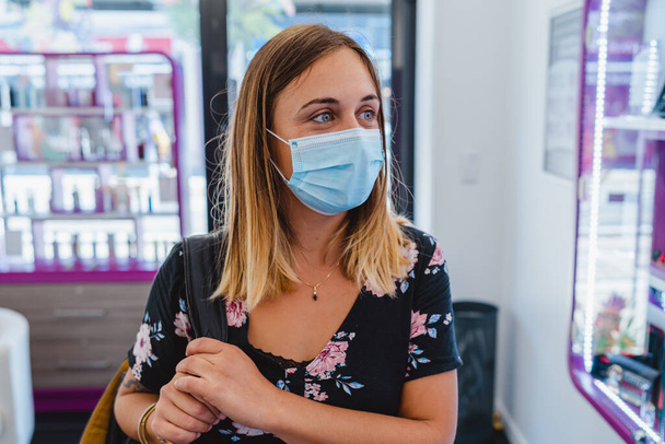 Молода жінка в захисній масці в роздрібному магазині
 - Фото, зображення