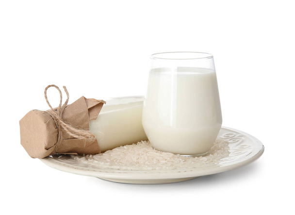 Bottiglia e bicchiere di latte di riso su fondo bianco - Foto, immagini