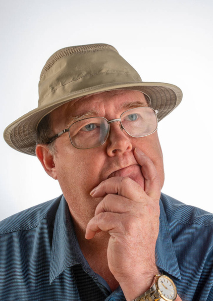 Portrait of middle aged man with facial expression, with blue shirt, glasses and hat with white background. - Φωτογραφία, εικόνα
