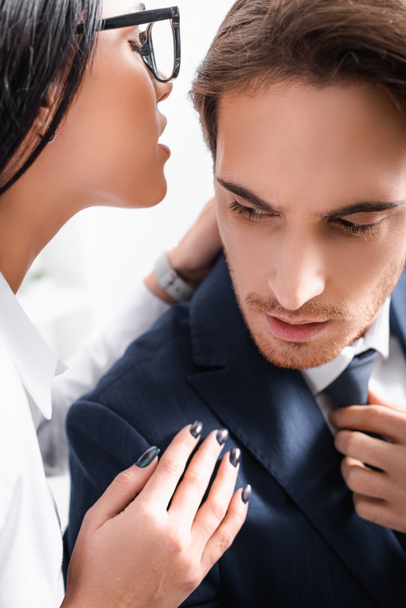 passionate businesswoman whispering in ear of colleague while flirting in office - Fotoğraf, Görsel