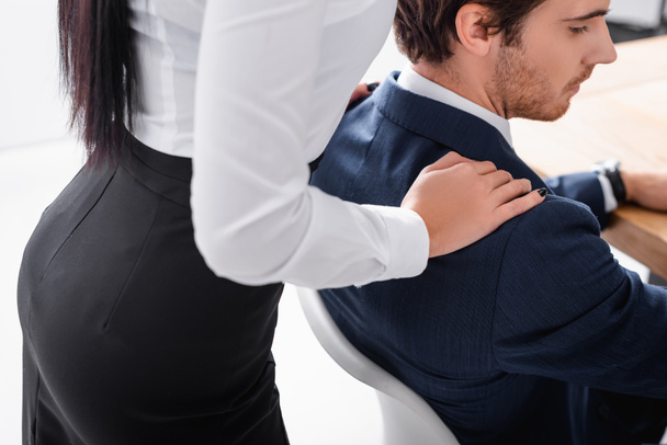sexy secretary touching shoulder of businessman in office - Фото, изображение