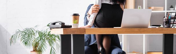 partial view of secretary sitting on desk while seducing businessman in office, banner - Photo, Image