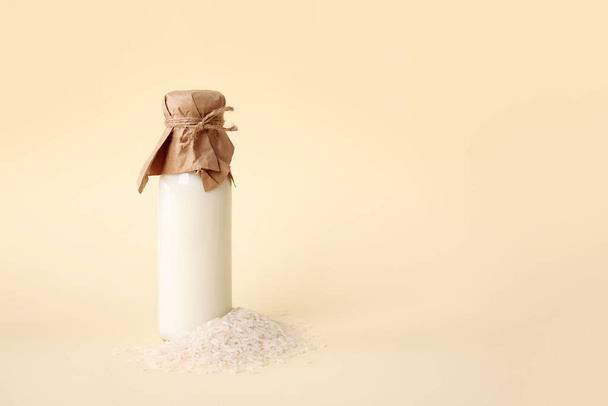 Fles rijstmelk op kleur achtergrond - Foto, afbeelding