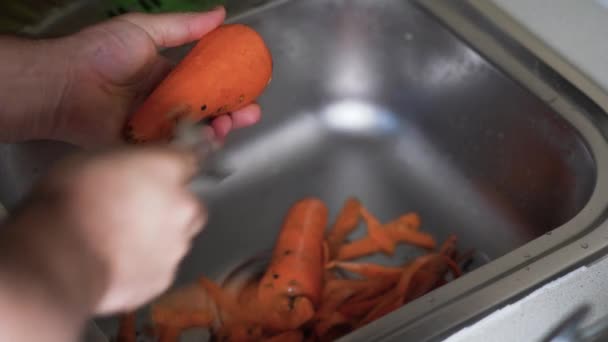 Lavaggio a mano delle carote sotto l'acqua corrente - Filmati, video
