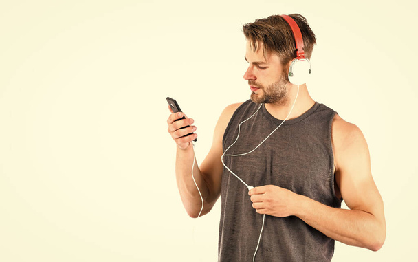 Man handsome unshaven hipster listening audio file using headphones gadget. Modern earphones concept. Audio education. Listen music for motivation and inspiration. Audio quality. Audio track - Photo, image