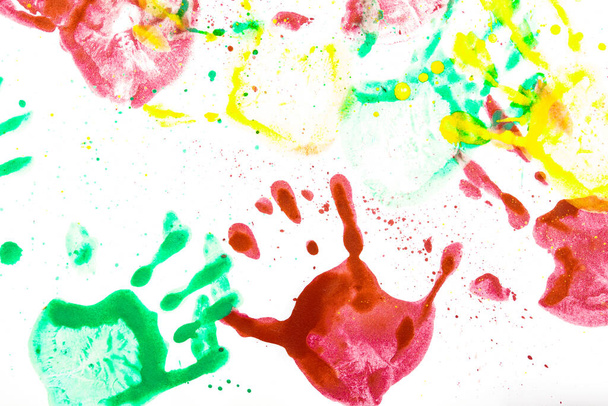 Múltiples impresiones a mano en color sobre un fondo blanco. Huellas de manos hechas por niños. - Foto, imagen