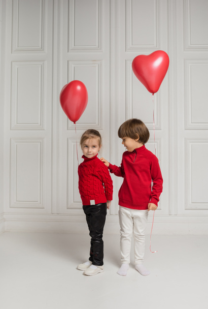 kleiner Junge und Mädchen mit herzförmigen Luftballons auf weißem Hintergrund - Foto, Bild