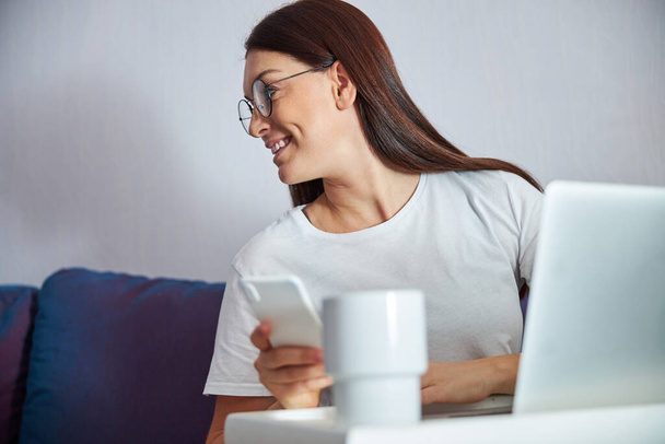 Cheerful female spending time with notebook indoors - Foto, Bild