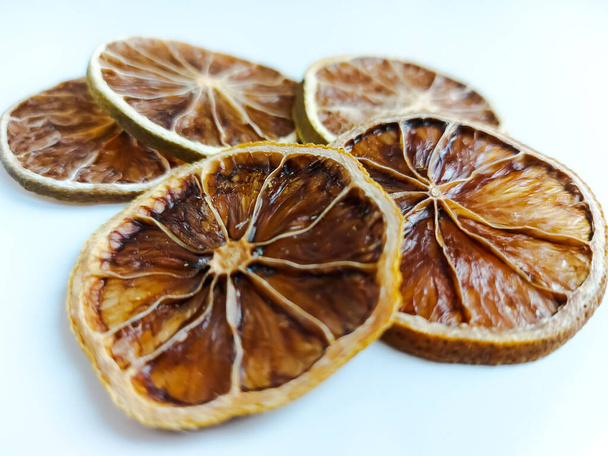 Круглые сухие ломтики лимона или грейпфрута на светлом фоне - Фото, изображение