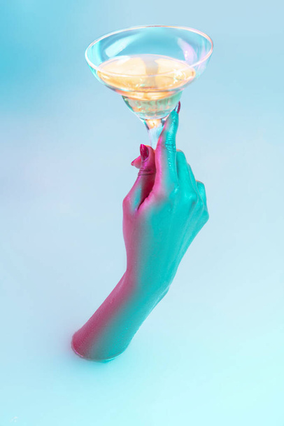 Close up female hand gesturing from the milk bath with soft glowing in neon light - Foto, Imagen
