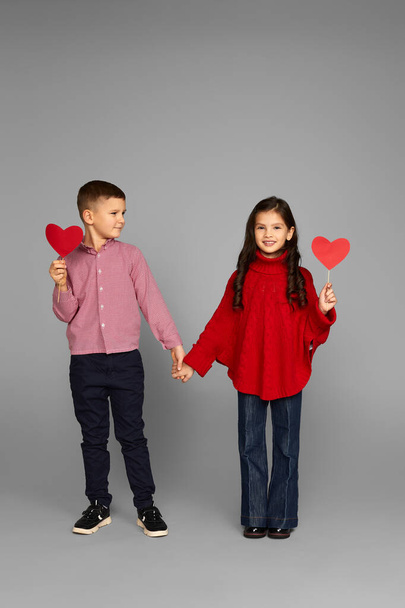 Happy couple little girl and boy with red hearts - Фото, зображення