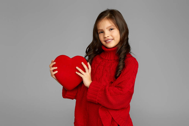 smiling child girl holding red heart - Фото, изображение