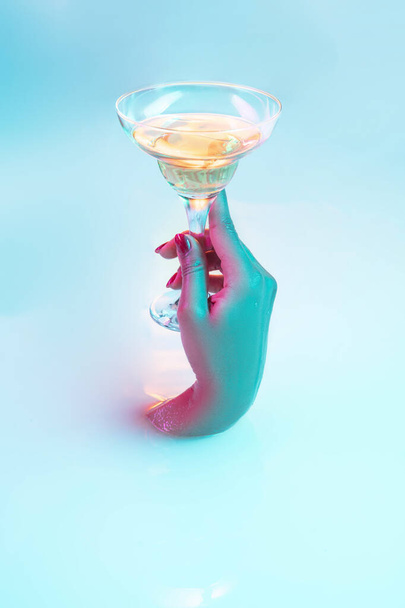 Close up female hand gesturing from the milk bath with soft glowing in neon light - 写真・画像