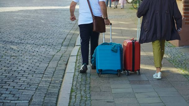 WISMAR, GERMANY - SEPTEMBER 23, 2019: back view of Senior going on  european street. woman and man travelling together, walking with baggage on city - Photo, image