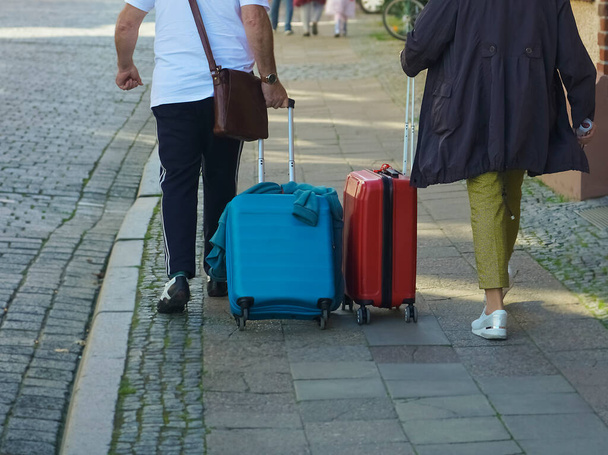 WISMAR, ALEMANHA - 23 de SETEMBRO de 2019: vista traseira de Senior indo na rua europeia. mulher e homem viajando juntos, andando com bagagem na cidade - Foto, Imagem